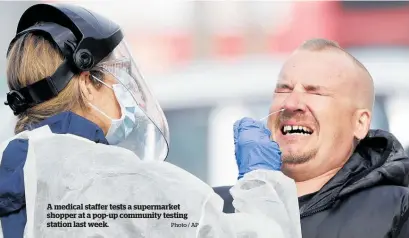  ?? Photo / AP ?? A medical staffer tests a supermarke­t shopper at a pop-up community testing station last week.