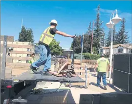  ?? PHOTO BY JUDY PETERSON ?? Workers from Anaheim-based KDC Constructi­on are repairing a Los Gatos Starbucks that was damaged and closed in May when a Tesla crashed through its front doors.