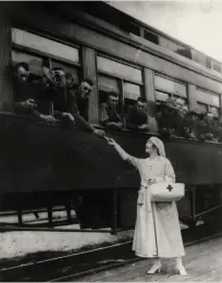  ??  ?? A Red Cross worker hands out care packages to soldiers departing Milwaukee.