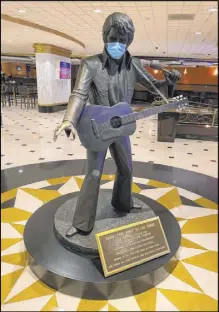  ?? John Katsilomet­es Las Vegas Review-Journal @JohnnyKats ?? A masked statue of Elvis Presley is seen Thursday at Westgate Las Vegas. Raiders owner Mark Davis would prefer a different color scheme for the face covering.