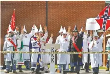  ?? STAFF FILE PHOTOS ?? Top: Ku Klux Klan members burn a cross in 1987. While it is impossible to say how many members the Klan has today, leaders claim thousands among scores of local groups. Above: Brother Jeff Jones, center, with microphone, and other members of the KKK...