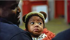  ?? MARVIN JOSEPH / WASHINGTON POST ?? Firefighte­r Jamill Blackman holds 9-month-old ZaNiyah Duckett on Tuesday at Engine Co. 19 firehouse in Washington, D.C.