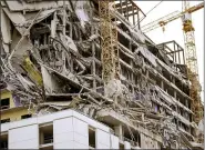  ?? (SCOTT THRELKELD/THE ADVOCATE VIA AP ?? Debris hangs on the side of the building after a large portion of a hotel under constructi­on suddenly collapsed in New Orleans on Saturday. Several constructi­on workers had to run to safety as the Hard Rock Hotel, which has been under constructi­on for the last several months, came crashing down.