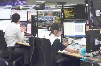  ?? — AFP ?? A currency dealer monitors exchange rates in a trading room at the KEB Hana Bank in Seoul, yesterday.