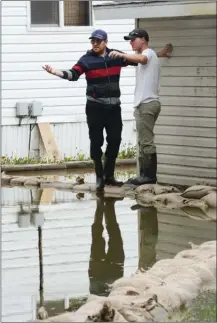  ?? GARY NYLANDER/The Daily Courier ?? Steve Davies, left, and Blaine Neil, employees of Meadowbroo­k Estates mobile home park, monitor flooding of the property Monday.