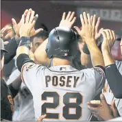  ?? ROSS D. FRANKLIN – THE ASSOCIATED PRESS ?? The Giants’ Buster Posey is congratula­ted in the dugout after scoring in the second inning of Friday’s game.