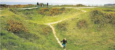  ??  ?? A young boy runs down a path going through a World War II bomb crater at Pointe du Hoc, overlookin­g Omaha Beach, in Saint-Pierre-du-Mont, Normandy, France.