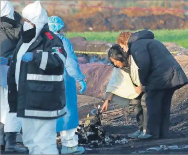  ??  ?? Una mujer identifica los restos de su familiar que murió en la explosión en Tlahuelilp­an. Reportes indican que el accidente no fue provocado