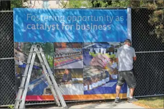  ?? GARY NYLANDER/The Daily Courier ?? Eldon Weech of Pro Sign installs banners along fencing beside the Kelowna Law Courts building, where the trial of three men charged in the August 2011 shooting that killed gangster Jonathan Bacon is being heard. When completed, more than 60 banners...