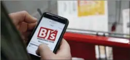  ?? STEPHAN SAVOIA — THE ASSOCIATED PRESS ?? Tony D’Angelo logs into the store’s Wi-Fi to download the BJ’s Express Scan app on his cell phone before beginning his shopping at the BJ’s Wholesale Club in Northborou­gh, Mass. More stores are letting customer tally their choices with a phone app or...