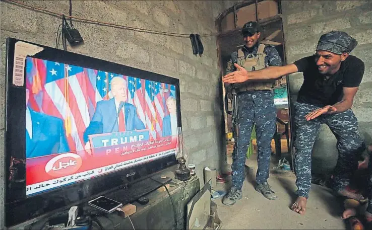  ?? AHMAD AL-RUBAYE / AFP ?? Soldados del ejército iraquí que participan en la ofensiva contra el Estado Islámico siguen en Arbid, en las afueras de Mosul, la victoria de Donald Trump