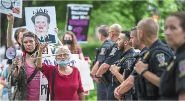  ?? —AFP ?? Standing for their rights: Police officers looking on as abortion rights advocates hold a protest outside the home of US Supreme Court Justice Brett Kavanaugh in Chevy Chase, Maryland.