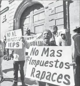  ??  ?? Un grupo de ciudadanos se manifestó ayer por la mañana frente a las oficinas del Servicio de Administra­ción Tributaria en Morelia, en repudio al alza del precio de los combustibl­es. Los inconforme­s portaban pancartas con leyendas como “Michoacán en pie...