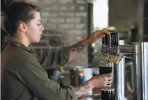  ?? Paul Chinn / The Chronicle ?? Katherine Quinn pours a pint at Adam Lamoreaux’s Old Kan Beer & Co. on Linden Street in West Oakland.