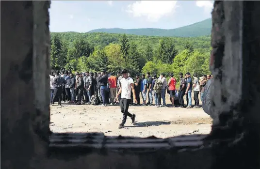  ??  ?? Un grup d’immigrants esperen rebre roba i menjar en un camp a prop de la ciutat de Bihac, a Bòsnia i Hercegovin­a.