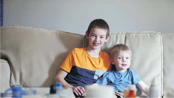  ?? MATT OLSON ?? Dominic and Benjamin Nechvatal sit in their house near a coffee table covered with the medication to help treat their cystic fibrosis.