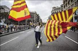  ?? SANTI PALACIOS / ASSOCIATED PRESS ?? A woman waves flags of Catalonia and Spain during a celebratio­n in Barcelona of Spain’s national day Thursday. About 65,000 people marched to a central square in the Catalan capital shouting “Long live Spain.”