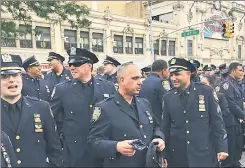  ??  ?? BAD BLOOD: Officers in uniform (above) turn their backs on the church building Tuesday during the speech by Mayor de Blasio, who arrived at the funeral service with his wife, Chirlane McCray (below).