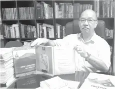  ??  ?? Yong holding a book on Malaysia Agreement 1963.