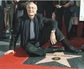  ??  ?? ACADEMY AWARD winning actor Martin Landau sits on his new star on the Hollywood Walk of Fame, as he poses for photograph­ers during ceremonies to honor him, in Hollywood, Dec. 17, 2001.