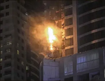  ?? KAMRAN JEBREILI / ASSOCIATED PRESS ?? Smoke and flames shoot out from the Torch Tower in the Marina district of Dubai, United Arab Emirates, on Friday. The blaze broke out about 1 a.m. Friday in one of the world’s tallest residentia­l towers, engulfing part of the skyscraper and sending...