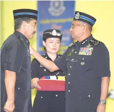  ??  ?? Fuzi (right) presenting a medal to a recipient.