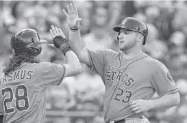  ?? John Sleezer / Kansas City Star ?? It didn’t take long for Astros rookie A.J. Reed, right, to make an impact after his call-up, walking in the second inning and then scoring on a Luis Valbuena double.