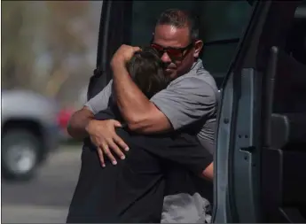  ?? John Roark /The Idaho Post-Register via AP ?? People embrace after a school shooting at Rigby Middle School in Rigby, Idaho on Thursday.