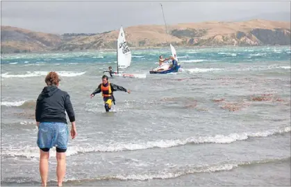  ?? Photos: JOHN CHIPPER ?? Wild ride: Young sailors struggle to return to shore after a fierce southerly whipped up the waters near Plimmerton.