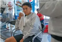  ?? AP PHOTO/ERIN HOOLEY ?? Yoli Cordova, 42, of Venezuela, wipes her face Sept. 20 as she sits in a makeshift shelter for migrants at O’Hare Internatio­nal Airport in Chicago.