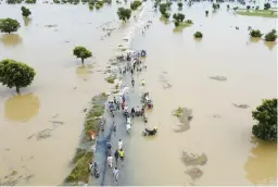  ?? AP 2022 ?? Flooding obscures a roadway last September in Hadeja, Nigeria. A new UN report on climate change had been held up by a dispute between rich and developing countries.