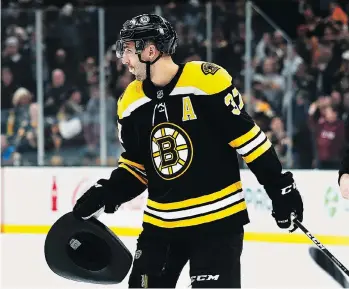  ?? WINSLOW TOWNSON/THE ASSOCIATED PRESS ?? Bruins centre Patrice Bergeron carries a cowboy hat to the bench after scoring a hat trick in a recent win over the Ottawa Senators. Bergeron is among the NHL’s scoring leaders.