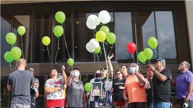  ?? Staff photo by Sara Vaughn ?? ■ Family and friends release biodegrada­ble balloons in front of Bi-State Justice Building on Thursday, Morgan Angerbauer’s birthday. Angerbauer, a diabetic, died in a nursing observatio­n cell at the Bi-State after being denied medical treatment in 2016. The family plans to release balloons each year to honor her memory.