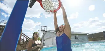  ??  ?? Omiyosiw Warren, left, watches her sister Kiihibaa Warren dunk the ball in their new pool — one of the perks to staying home with the powwow circuit being cancelled due to the COVID-19 pandemic. “The swimming pool and trampoline are really what we wanted as kids. The ability to give that to our kids was important,” TJ says. “We really wanted to make our home a place where they want to be.”