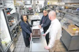  ?? JIM WITMER / STAFF ?? Mary Miller in the Wellington Grille kitchen with server Tom Fair (black shirt), who has worked for Miller for about 20 years, and Daniel Warner, general manager (white shirt). Miller said she still gets immense satisfacti­on from operating restaurant­s,...