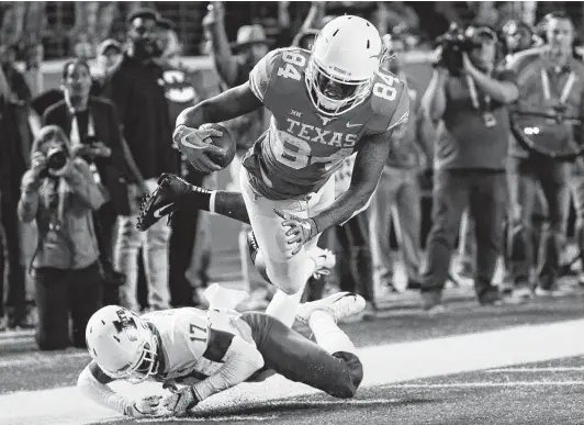  ??  ?? Texas wide receiver Lil'Jordan Humphrey leaps over Iowa State defensive back Richard Bowens III to score a touchdown on a 27-yard pass in the third quarter. Eric Gay / Associated Press