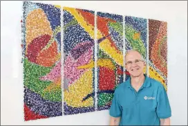 ?? EMILY HANEY / EMILY.HANEY@AJC.COM ?? Shulman poses for a portrait next to one of his pieces of art at the Laureate Medical Group in Atlanta. This piece is made from melted crayon. It is one of 38 pieces on display in four Laureate offices across the metro area.