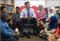  ?? MARK BLINCH, THE CANADIAN PRESS ?? Finance Minister Bill Morneau takes part in the pre-budget tradition of putting on new shoes, at the Nelson Mandela Park Public School in Toronto on Monday.