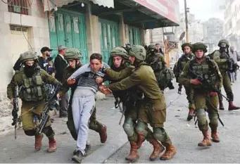  ?? Reuters ?? Israeli soldiers detain a Palestinia­n during clashes at a protest in Hebron in the occupied West Bank yesterday.