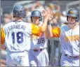  ?? L.E. Baskow Las Vegas Review-journal ?? Aviators catcher Dustin Garneau gets a high-five from third baseman Mikey White after scoring in 2019.