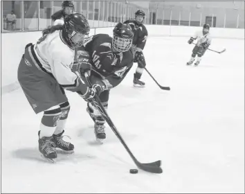  ?? CAROLE MORRIS-UNDERHILL ?? To stay up-to-date on high school hockey news and see more photos, visit Maddie Singer locks sticks with Flames player in hopes of stealing the puck.