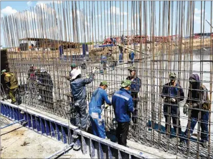  ?? NIKOLAI TRISHIN / TASS ?? Constructi­on work on a new neighborho­od takes place in Mariupol, Ukraine, on June 18. The city has been largely devastated after months of fighting and siege. NATO’s eastward expansion has been blamed as the root cause of the Ukraine crisis.