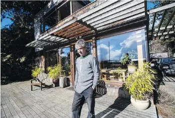  ??  ?? Doug Harvey, in front of his house in Jordan River, plans to have the two-storey home moved farther up the hill before selling it and then building another home closer to Sooke.