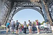  ?? AP ?? People queue up to visit the Eiffel Tower in Paris on Thursday.