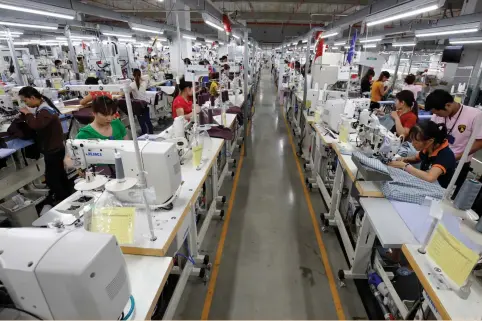  ?? (Kham/Reuters) ?? WORKERS MAKE garments at the TAL factory north of Hanoi last month. The wage for garment workers is $250 a month in Vietnam, compared with $700 in China, where TAL recently shut a factory for cost reasons.