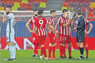  ??  ?? Los jugadores del Atlético protestan la jugada del gol a Felix Brych.