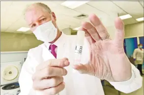  ?? Peter Hvizdak / Hearst Connecticu­t Media ?? Mark Kidd, clinical laboratory and scientific director of the Branford-based Wren Laboratori­es, holds a first-generation Wren Saliva Collection tube from a Wren Laboratori­es saliva-based PCR test for COVID-19 that can be done at home with a self-collection kit and sent in, eliminatin­g the need to go to a testing station.