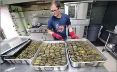  ?? ALEX HORVATH / THE CALIFORNIA­N ?? Nick Hackleman finishes the cooking process on freshly made dolmades (stuffed grape leaves) in the kitchen at St. George Greek Orthodox Church.