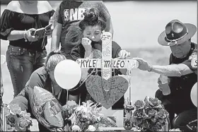  ?? AP/Houston Chronicle/MARIE D. DE JESUS ?? Mourners gather Tuesday around a memorial for Santa Fe High School freshman Aaron Kyle McLeod, who was killed in Friday’s shooting in Santa Fe, Texas.