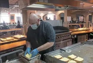  ?? Post-Gazette ?? Josh Bergman, production manager for Aramark, prepares peanut butter and jelly monte cristo sandwiches on Jan. 24 inside the Boozel Dining Hall at Slippery Rock University in Slippery Rock, Pa.